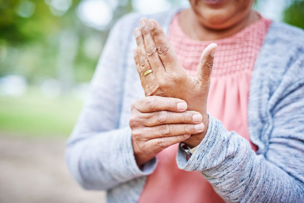 range of motion exercises for arthritis woman holding her hand in pain due to arthritis close up