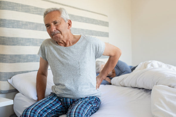 what causes back pain what are the different types of back pain natural remedies that can help elderly man getting out of bed with back pain wearing pjs