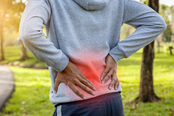 what is degenerative disc disease ddd man holding his lower back in pain red orb close up