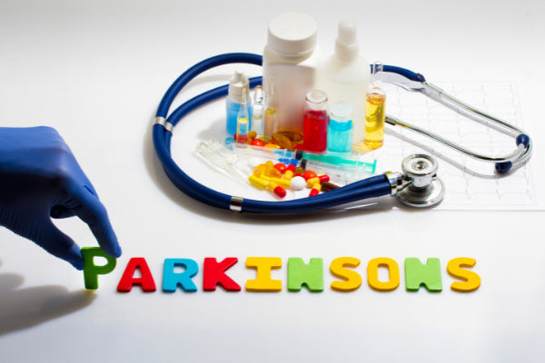 what is parkinsons disease spelled out in different color letters next to pill bottles stethoscope