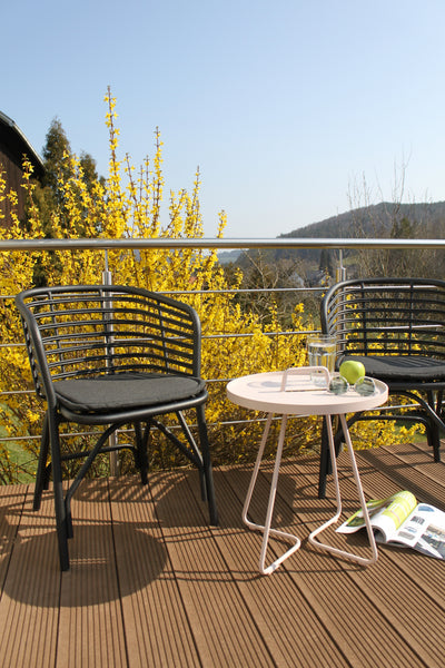 Two outdoor chairs and a small sidetable on the patio