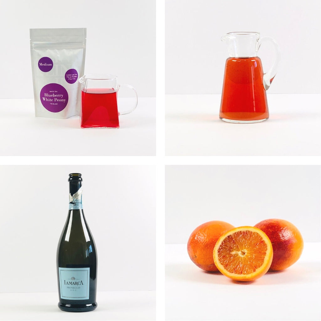 quadrant or blueberry white peony tea, pomegranate juice, bottle of prosecco and cut oranges