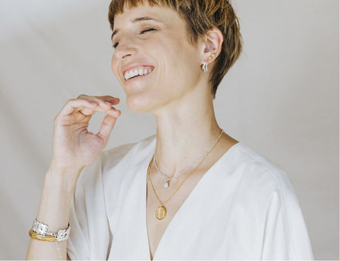 smiling woman with mixed metal jewellery