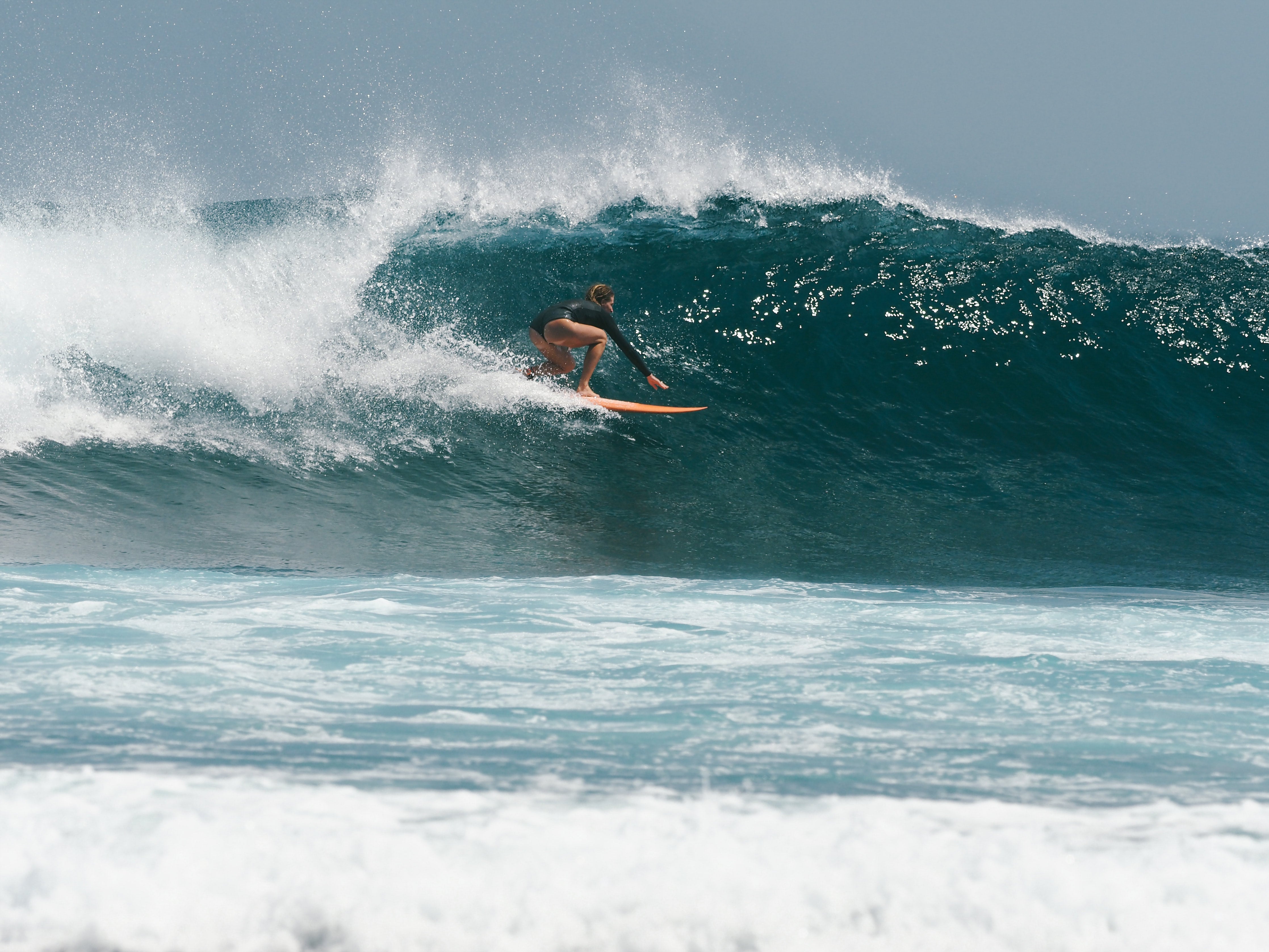 Cait surfer på en bølge på vej ind i tønden