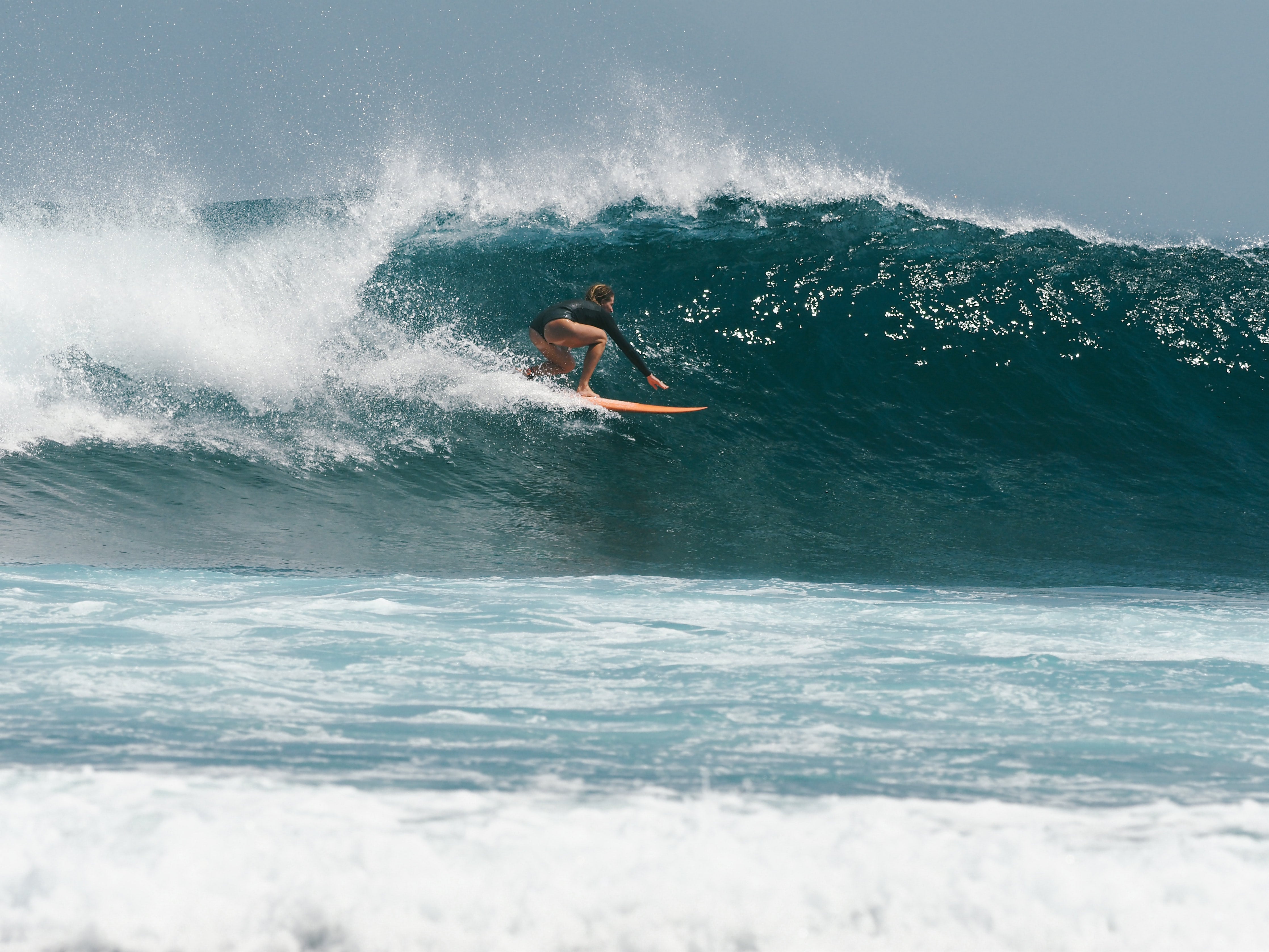 Cait surfeando una ola entrando en el barril