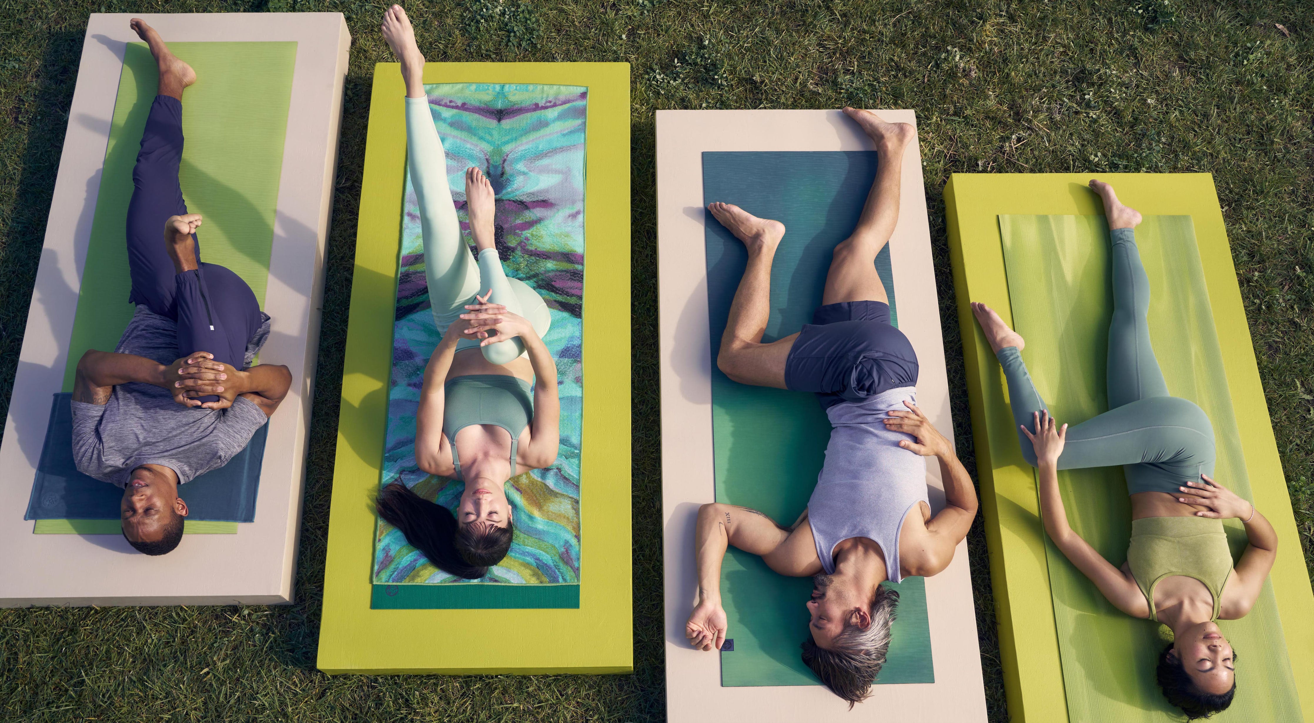 Vista dall'alto di praticanti di yoga che si stendono sul tappetino e fanno stretching