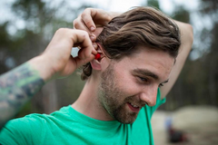 Man putting EarPeace in ears on construction site