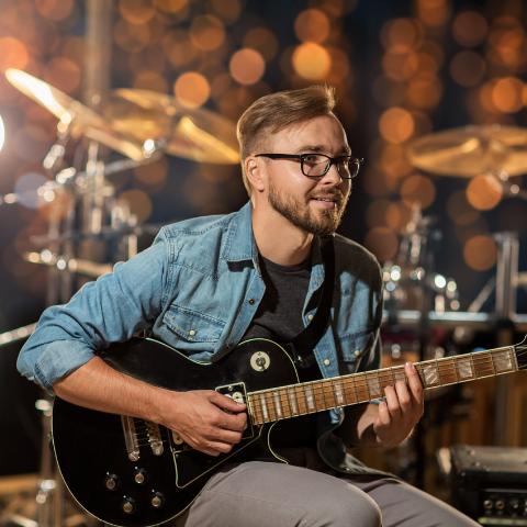 Man with glasses playing guitar