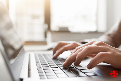 Person typing on a keyboard with sunset background