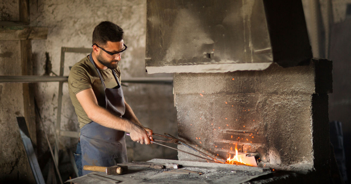 man is wearing a protective glasses while learning to blacksmith