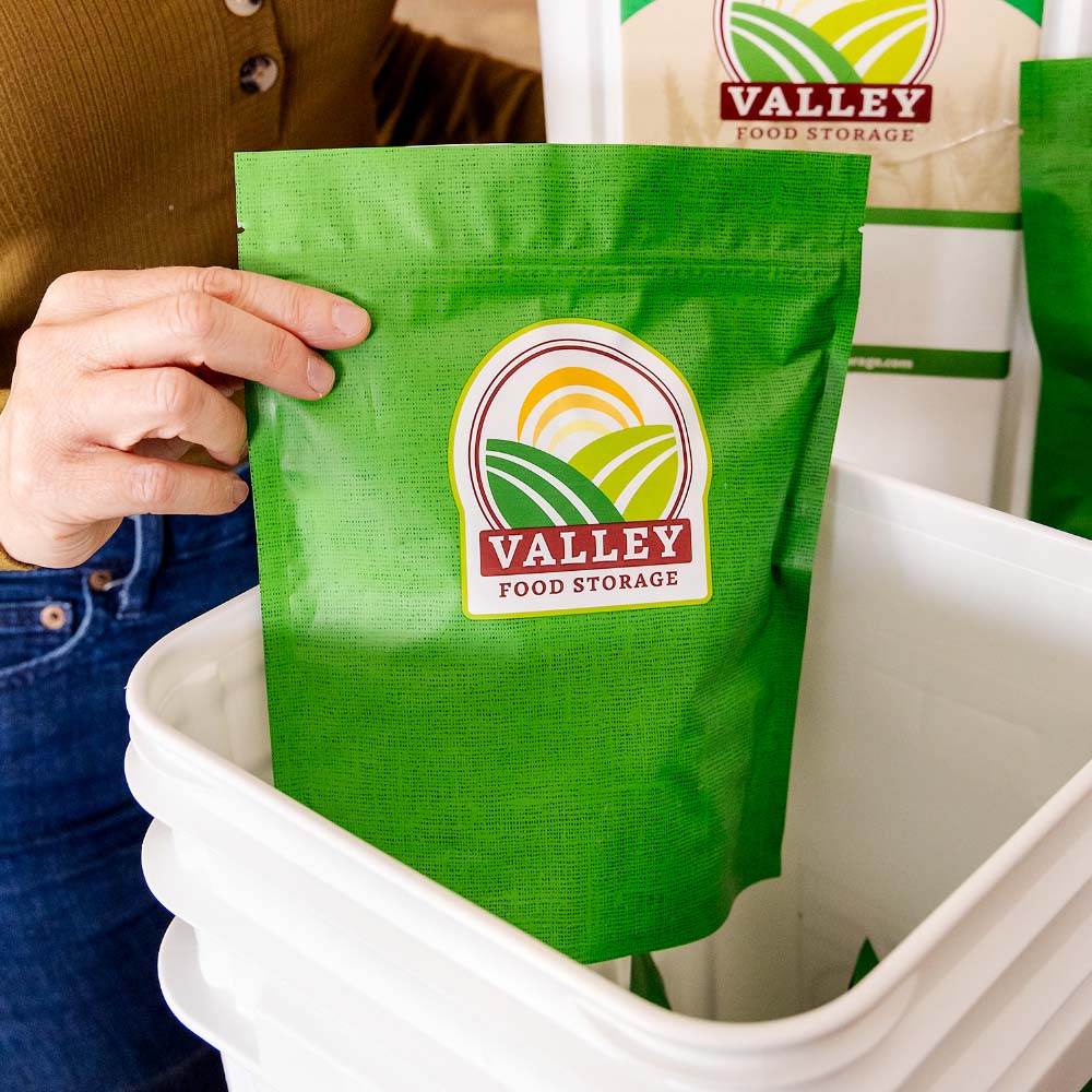 Placing a bag of freeze dried vegetables into an emergency bucket