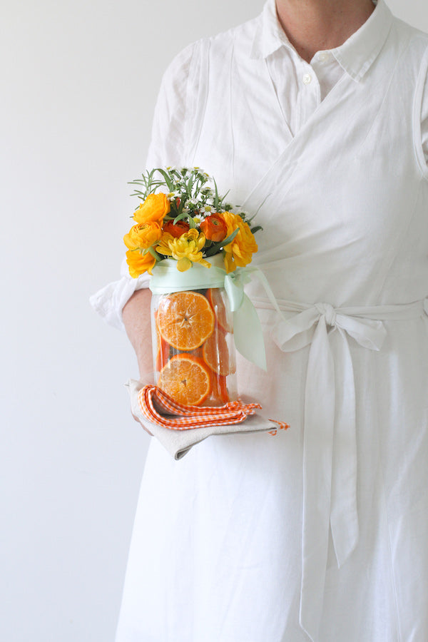 Cuisine Apron Dress in White Linen from Libbie Summers label, Sliced Orange Centerpiece, Flower design, Libbie Summers, Orange Gingham Linen Napkin