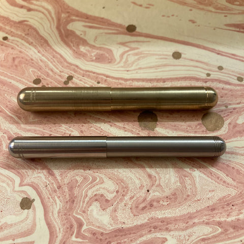 A Kaweco Liliput and a Kaweco Supra side by side on marbled paper