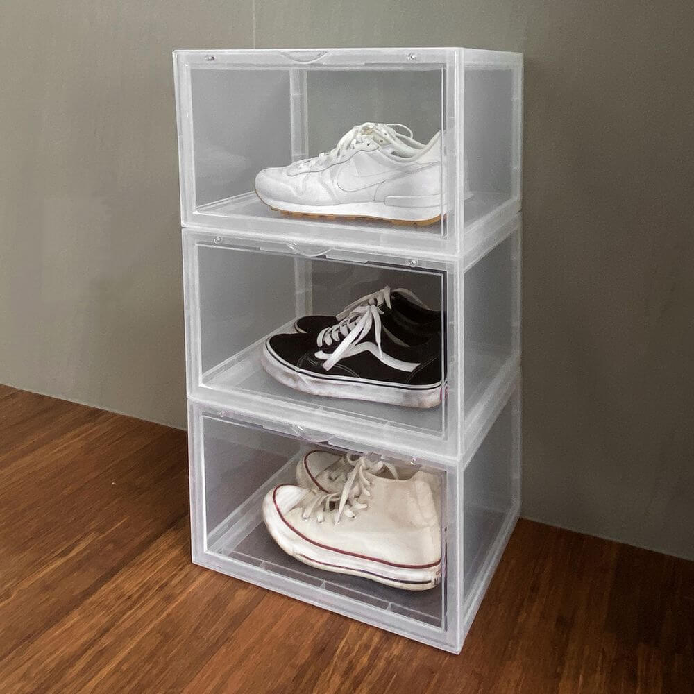 Three stackable plastic shoe boxes, with sneakers stored inside.