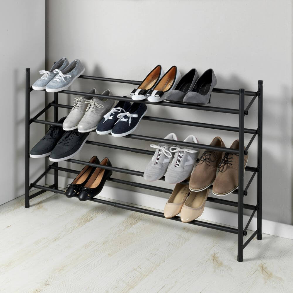 A matte black expanding shoe rack holding ten pairs of shoes. There are four storage shelves on the rack.