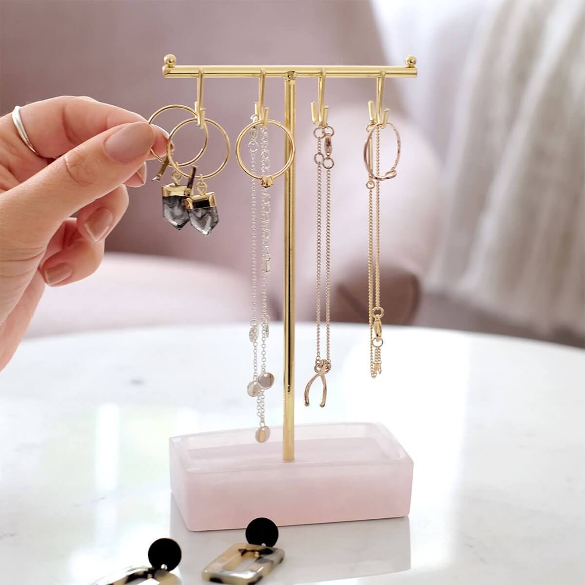 A mini Stackers hanging jewellery organiser with earrings and bracelets hanging on hooks