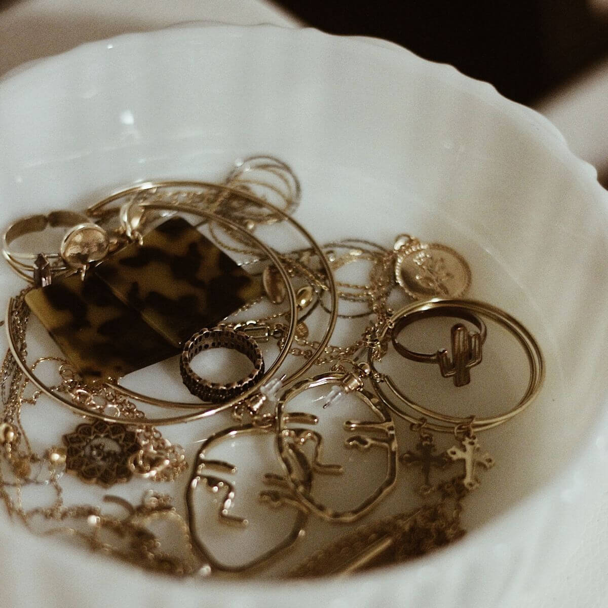 Gold jewellery stored inside a white jewellery organiser tray