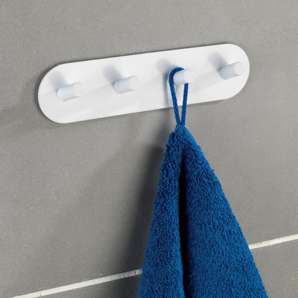 A white Turbo Lock adhesive suction hook strip installed on a tiled bathroom wall