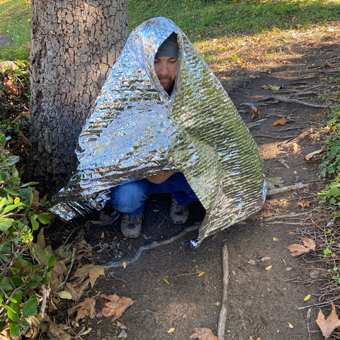 Man using emergency blanket to keep warm