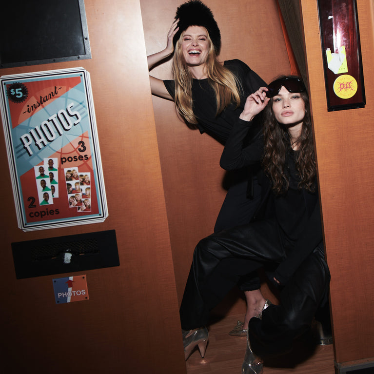 Modellen in feestelijke all-black kleding in een photo booth