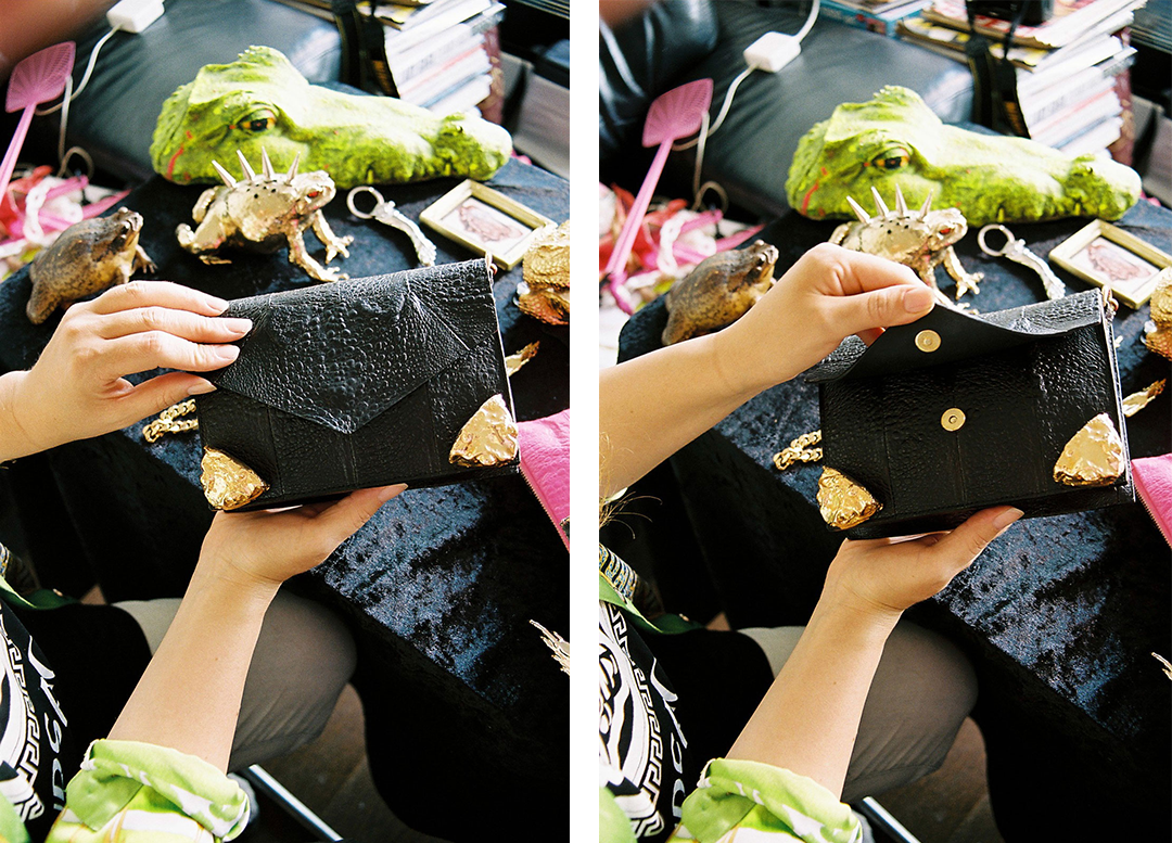 a cane toad leather handbag in black with gold metal corners
