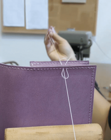 Simone saddle hand stitching a lavender leather bag