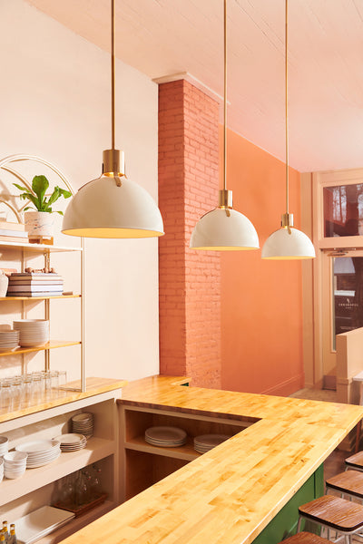 A series of Mid-Century Modern Pendant Lights showcased above a cafe counter eating area.