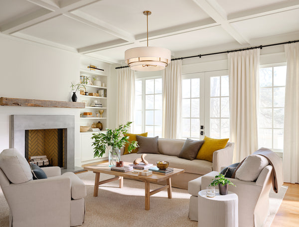 A drum chandelier with an infusing glow of a warm, inviting light, in a modern living room setting.