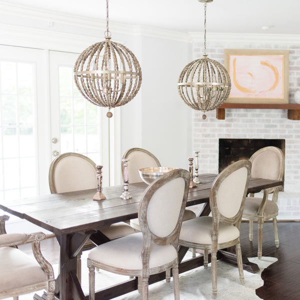 Twin orb chandeliers add a touch of whimsy and rustic elegance to a dining room.