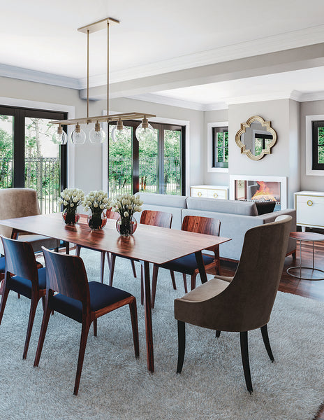 Elegant linear chandelier above a modern style dining a table.