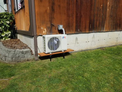 Aesthetically pleasing picture of an outside condenser sitting on a platform routing into a wooden house