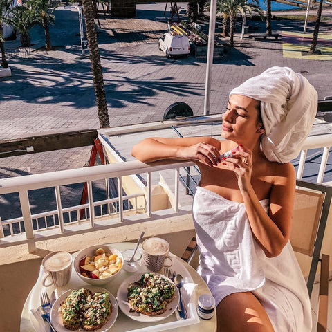 Facetheory Blog: Falten Vorbeugen - Kundenbild Frau sitzt auf Balkon in der Sonne mit Facetheory Produkten