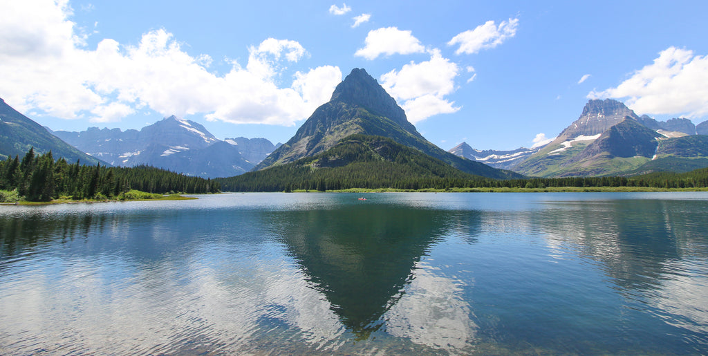 A small kayak shot in the middle of Swiftcurrent Lake in Many Glacier