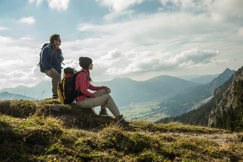 man and woman hiking with their travel backpacks