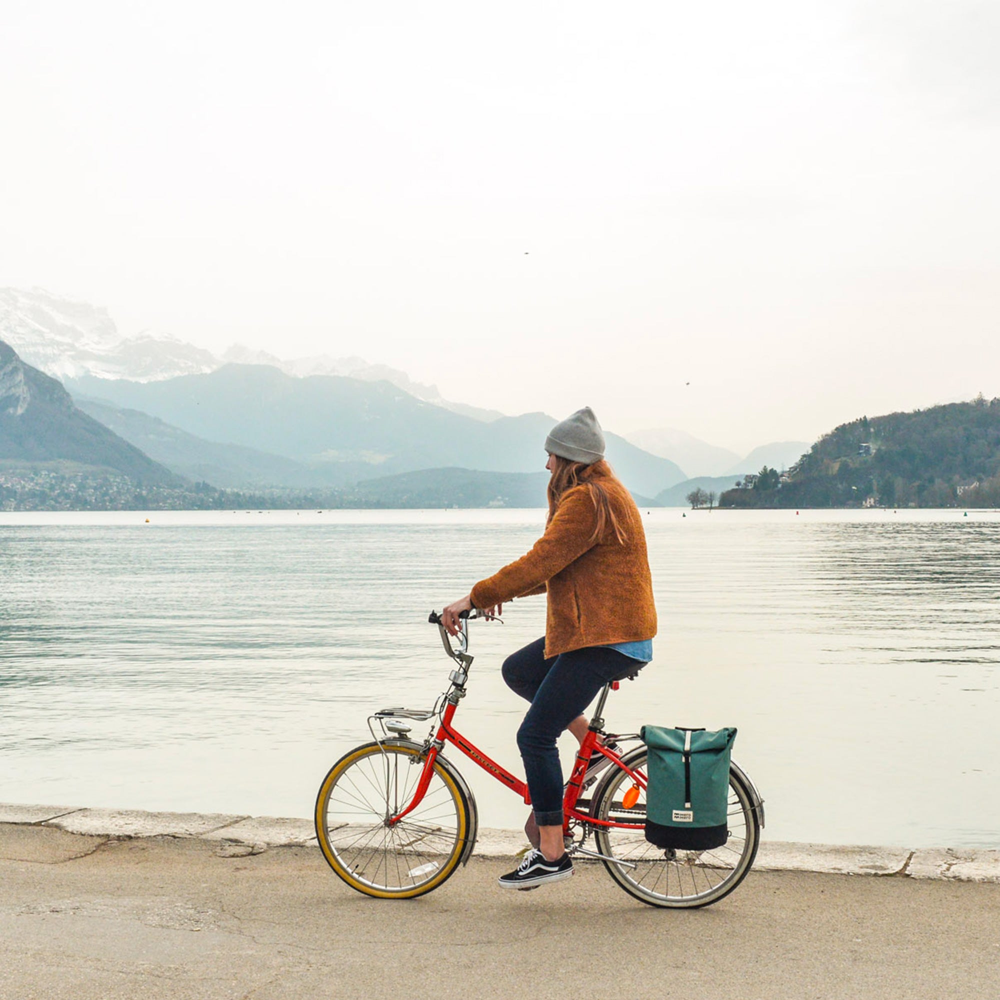 femme faisant la navette avec un sac à dos vélo roll top en matériaux recyclés de mero mero, idéal pour les trajets vélo en ville