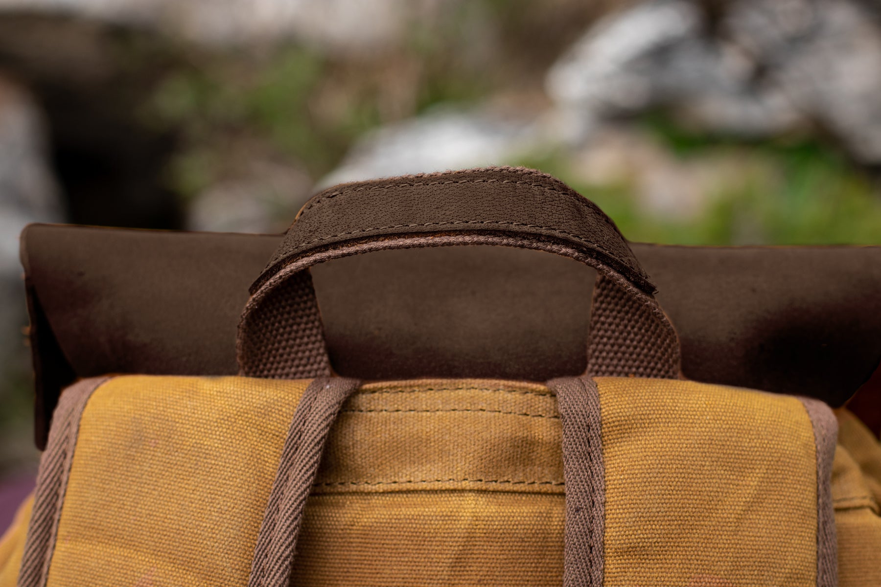 close up view of the leather cap and the top leather handle of the water repellent vintage waxed bag