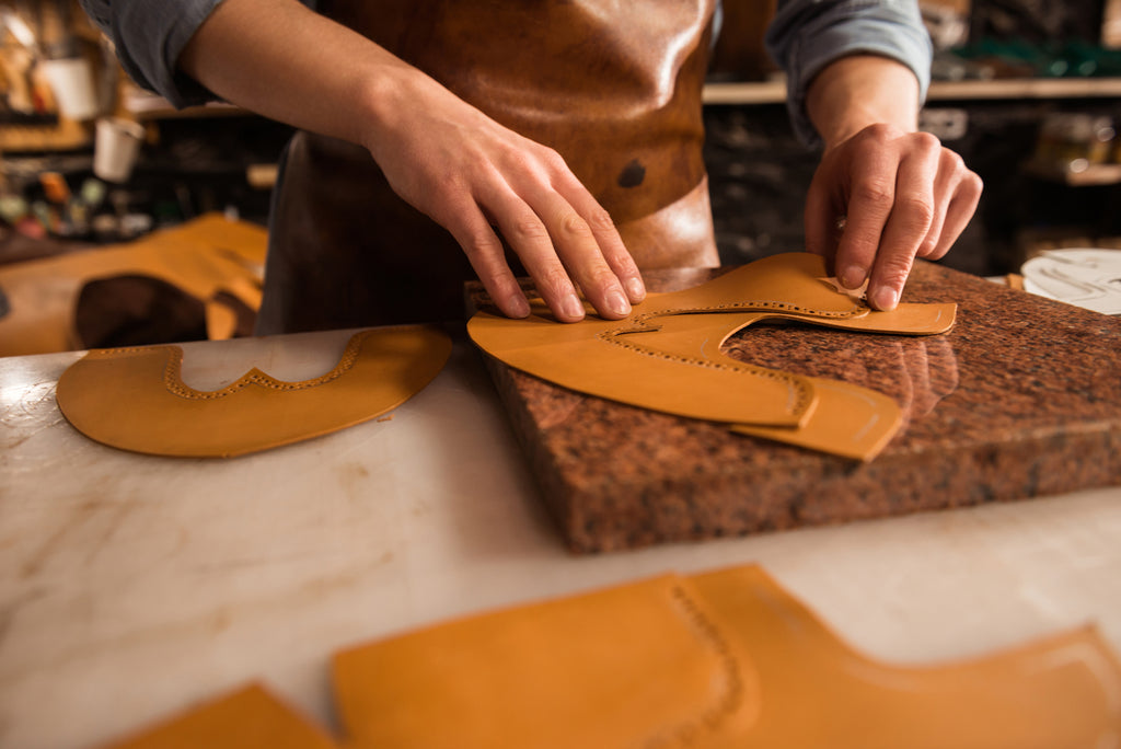 Close up of a shoemaker measuring leather