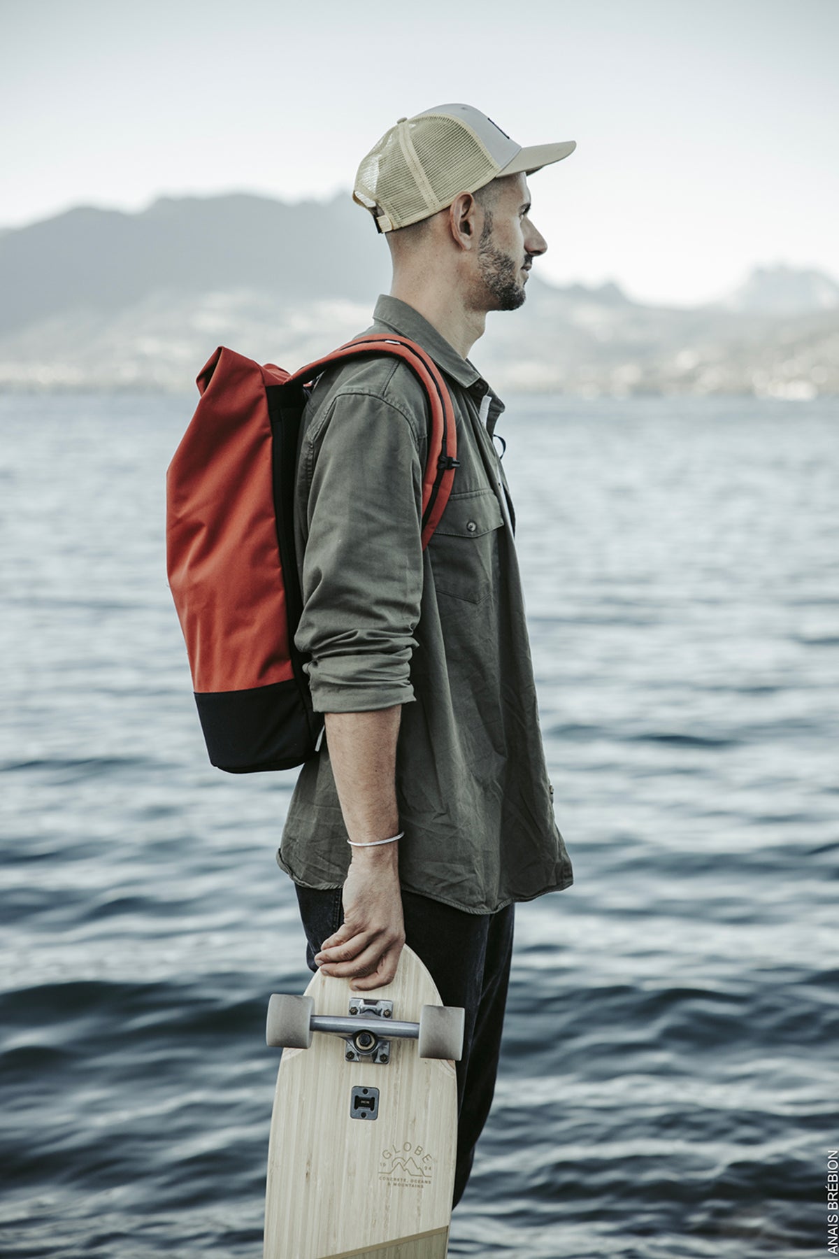 voyageur commuteur sur un ponton portant un sac à dos fabriqué à partir de matériaux recyclés de couleur rouge