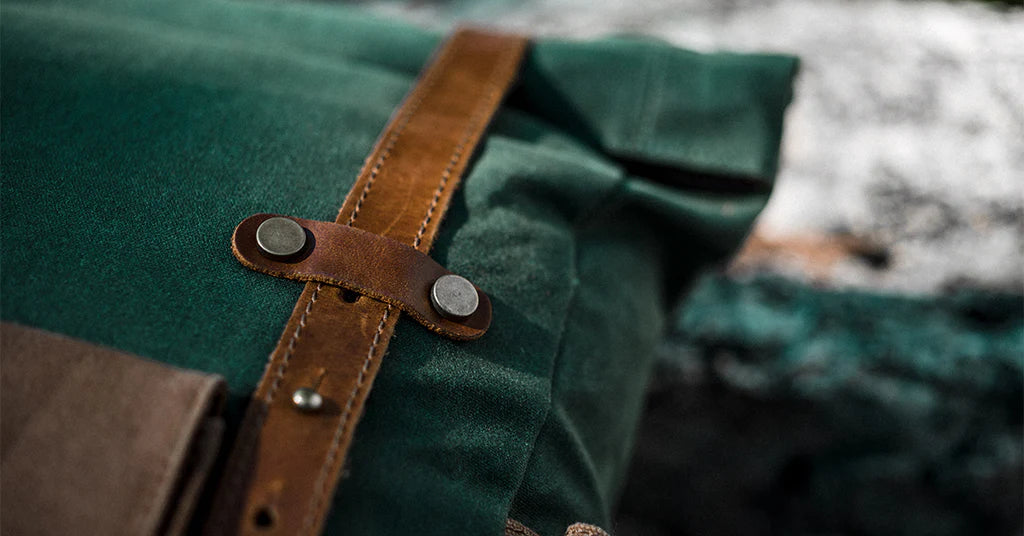 close up view of the full grain leather adjustable shoulder strap and waxed canvas fabric of a canvas rucksack