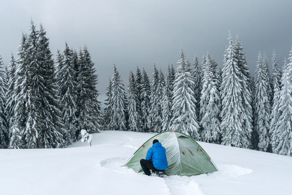 Tente verte dans les montagnes en hiver