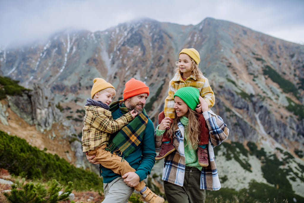 happy parents with their little kids on piggyback