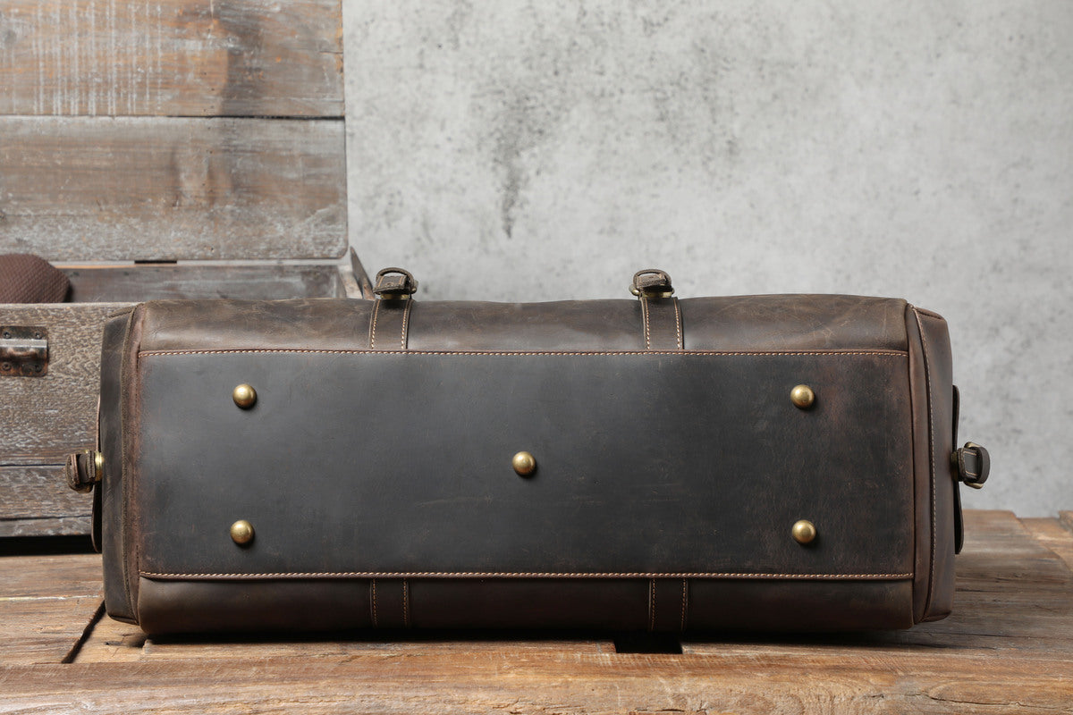 bottom view of a brown leather travel duffle bag