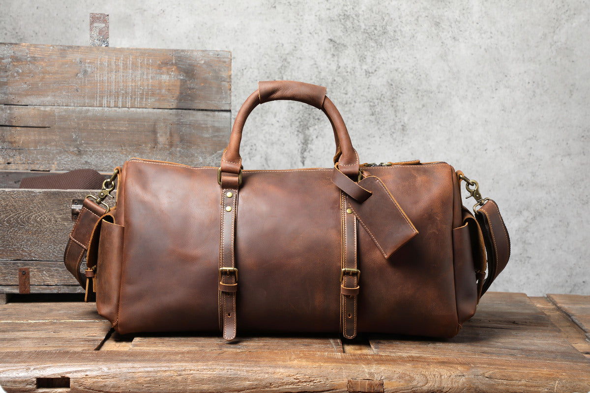 vintage coffee leather travel duffle bag on a wooden table