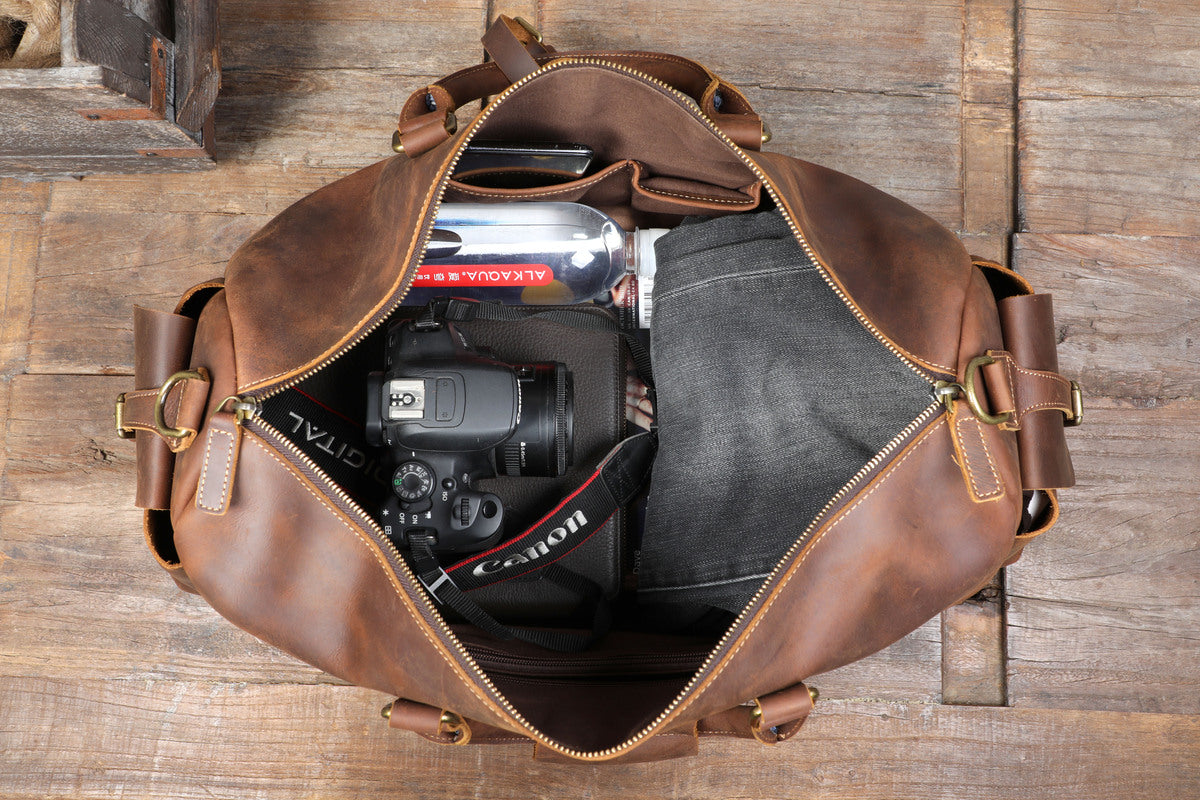 open leather travel duffle bag showing its content