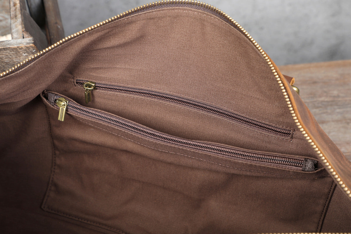 interior handy and spaicous zippered pockets of a leather travel duffle bag