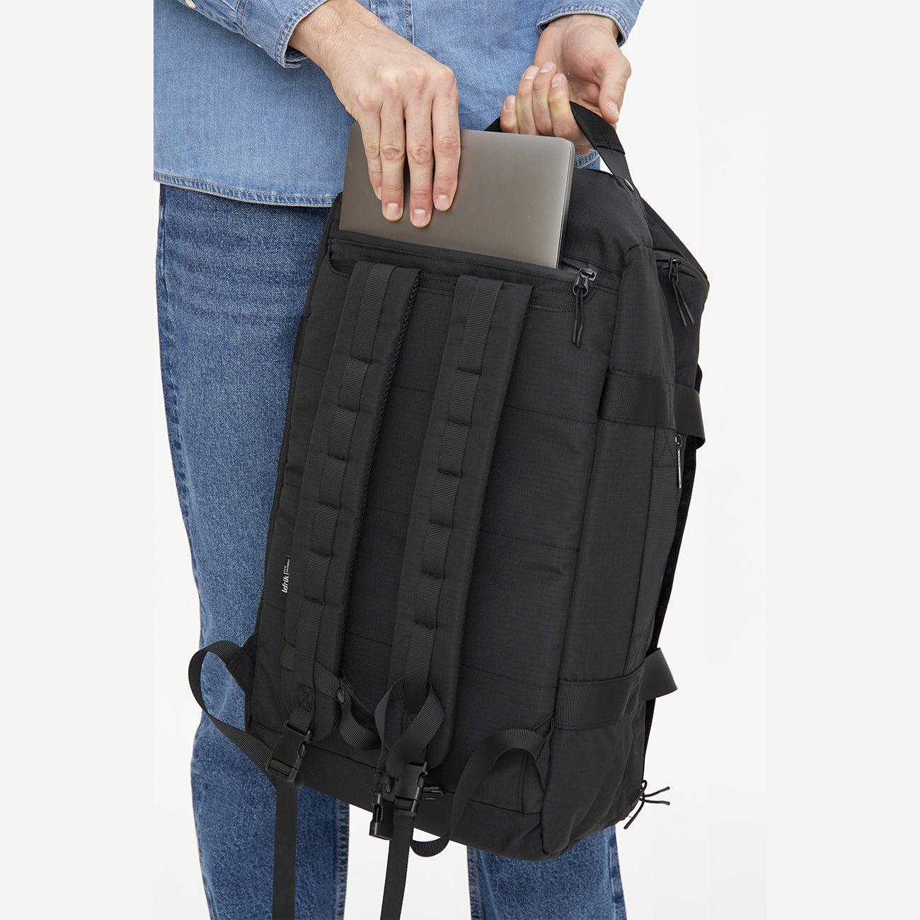 Gros plan de la poche secrète pour ordinateur portable au dos du sac à dos convertible de voyage durable