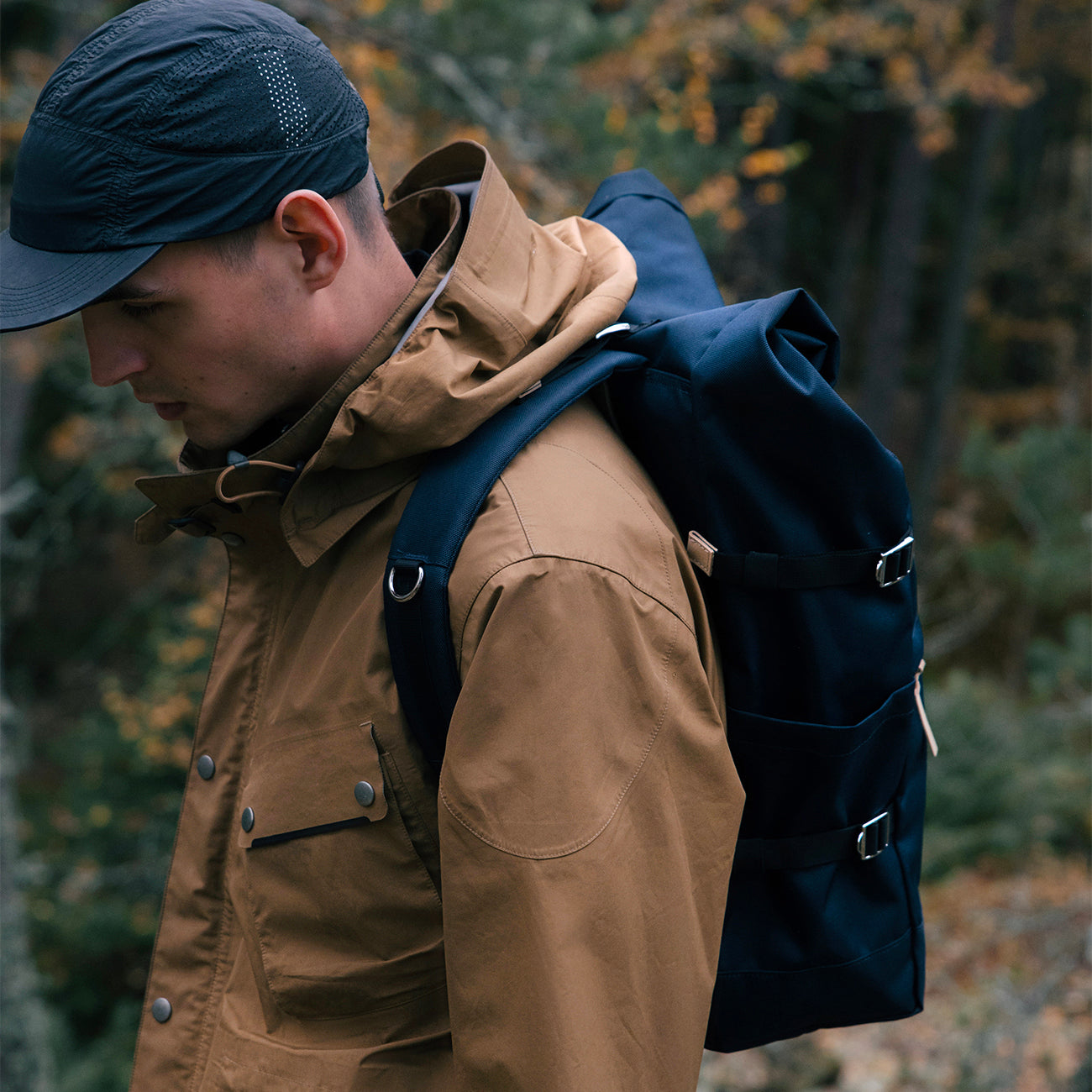 homme portant petit sac à dos roll top recyclé bleu