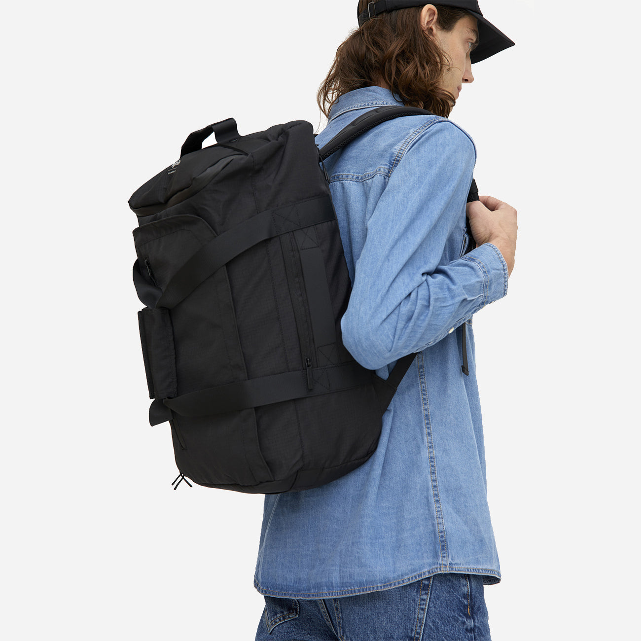 Homme portant un sac à dos convertible éco-responsable noir, vue latérale