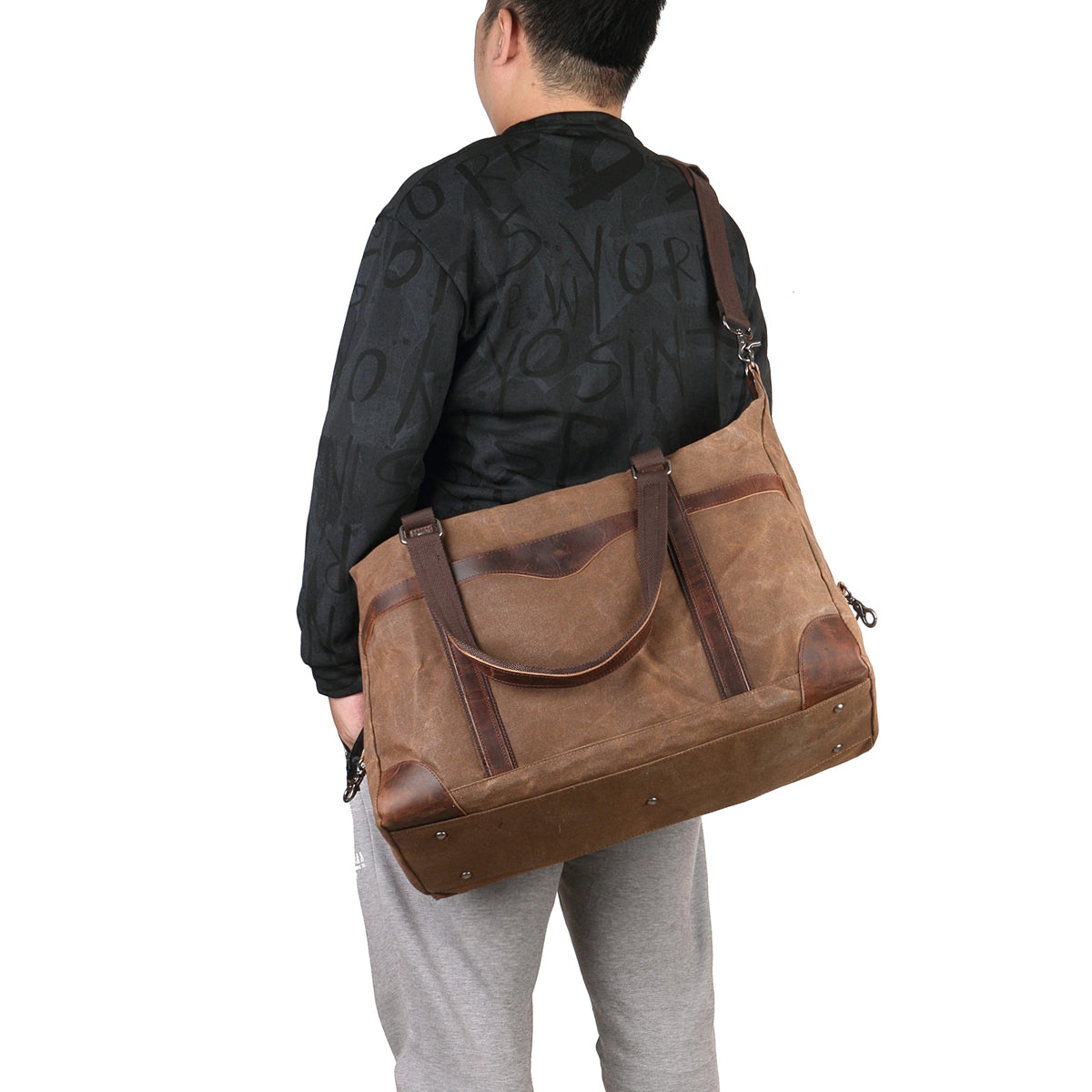 homme portant un sac de voyage toile et cuir couleur café