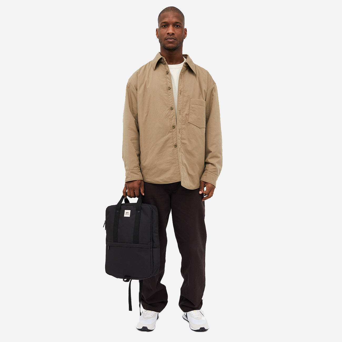 Homme tenant un sac à dos urbain écologique noir, vue avant